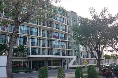 a large building with trees in front of it at ZcapeX2 condominium in Bang Tao Beach
