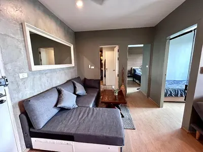 a living room with a couch and a table at ZcapeX2 condominium in Bang Tao Beach