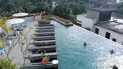 a swimming pool with people in the water at Veloche Karon palm in Phuket Town