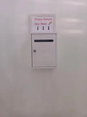 a white refrigerator with a sign that reads please return key here at XX BAO Patong Beach Phuket 3 in Patong Beach