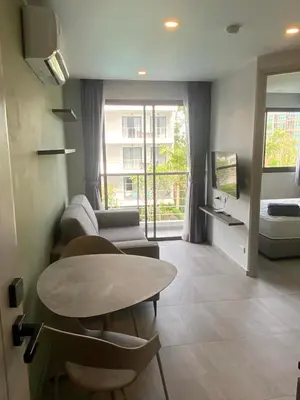 a living room with a table and a couch at CondoHotel Chalong in Ban Klang