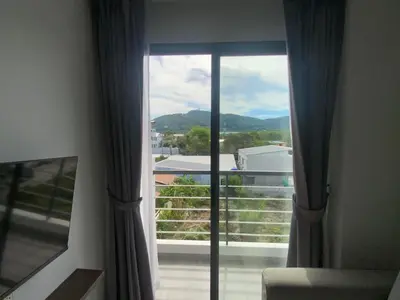 a large window with a view of a balcony at CondoHotel Chalong in Ban Klang