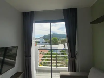 a room with a large window with a view at CondoHotel Chalong in Ban Klang