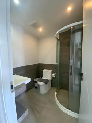 a bathroom with a toilet and a glass shower at CondoHotel Chalong in Ban Klang