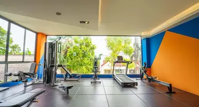a gym with several tread machines and a large window at CondoHotel Chalong in Ban Klang