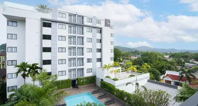 an exterior view of a building with a swimming pool at CondoHotel Chalong in Ban Klang