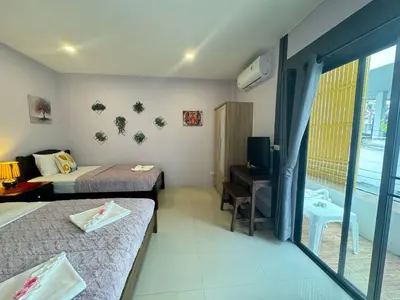 a hotel room with two beds and a television at Pupa Rooms in Patong Beach
