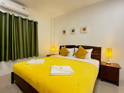 a bedroom with a yellow bed with two towels on it at Pupa Rooms in Patong Beach