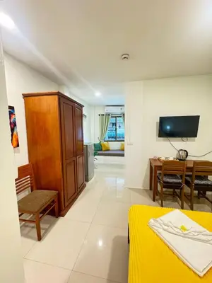 a room with a bedroom with a desk and a tv at Pupa Rooms in Patong Beach
