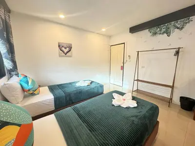 a room with two beds with flowers on them at Pupa Rooms in Patong Beach
