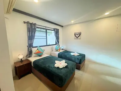 a bedroom with two beds with flowers on them at Pupa Rooms in Patong Beach