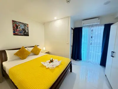 a bedroom with a yellow bed with a yellow blanket at Pupa Rooms in Patong Beach