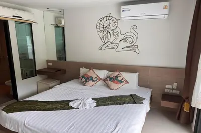 a bedroom with a bed with white sheets and pillows at JZ Patong in Patong Beach