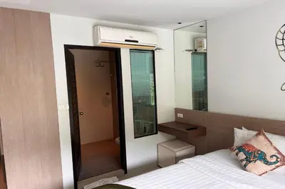 a small bedroom with a bed and a mirror at JZ Patong in Patong Beach