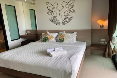 a bedroom with a bed with two towels on it at JZ Patong in Patong Beach