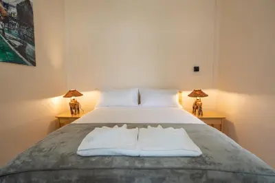 a bedroom with a bed with white sheets and two lamps at Coral Lagoon Pool Villa Rawai - Adult Only in Rawai Beach