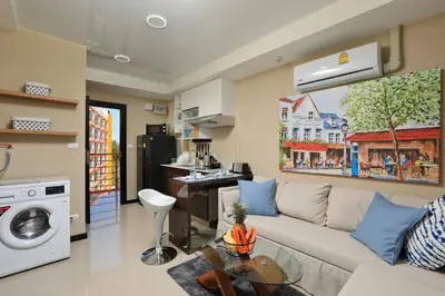 a living room with a couch and a table at Mai Khao Beach Condo by Capital Pro in Mai Khao Beach