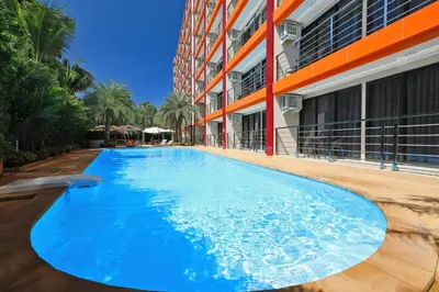 a large blue swimming pool next to a building at Mai Khao Beach Condo by Capital Pro in Mai Khao Beach