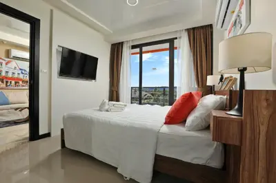a hotel room with a bed with a window at Mai Khao Beach Condo by Capital Pro in Mai Khao Beach