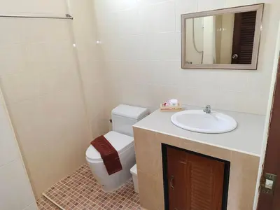 a bathroom with a toilet and a sink and a mirror at Baan Thawin in Patong Beach