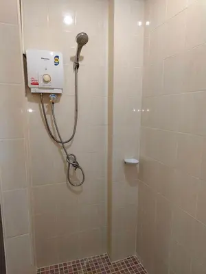 a shower in a bathroom with a shower head at Baan Thawin in Patong Beach