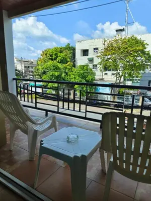 a balcony with two chairs and a table and a view at Baan Thawin in Patong Beach