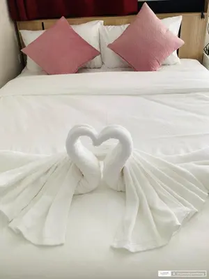 two swans forming a heart on a bed at Sunshine guesthouse in Ban Saiyuan (1)
