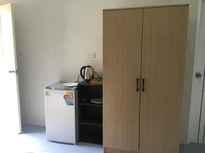 a kitchen with a cupboard next to a refrigerator at Sunshine guesthouse in Ban Saiyuan (1)
