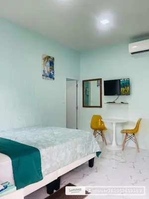 a bedroom with a bed and a table and a chair at Sunshine guesthouse in Ban Saiyuan (1)