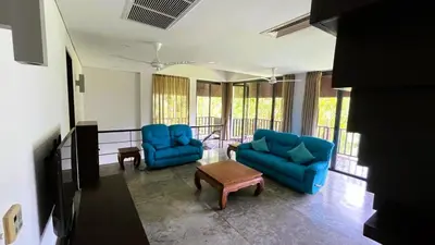 a living room with two blue chairs and a table at 23 - Seaside Villa Retreat in Phuket Town