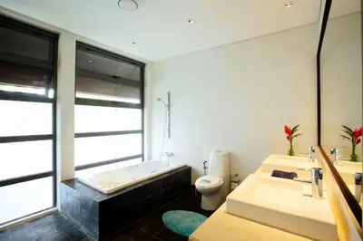 a bathroom with two sinks and a tub and a toilet at 23 - Seaside Villa Retreat in Phuket Town