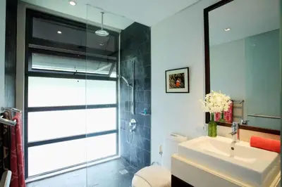 a bathroom with a sink and a glass shower at 23 - Seaside Villa Retreat in Phuket Town