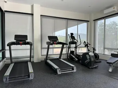 a gym with treadmills and ellipticals in a room with windows at Title Halo Time for Jungle 40m2 King Bed Pool in Nai Yang Beach