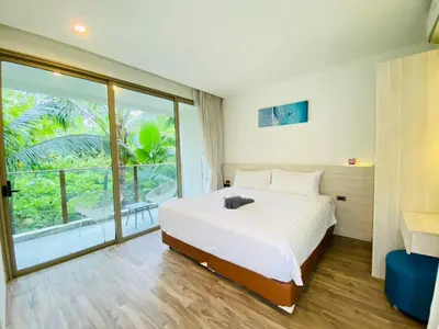 a bedroom with a white bed and a large window at A16 Oceana Kamala in Kamala Beach