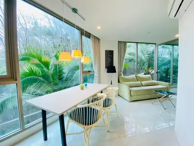 a living room with a table and chairs and a couch at A16 Oceana Kamala in Kamala Beach