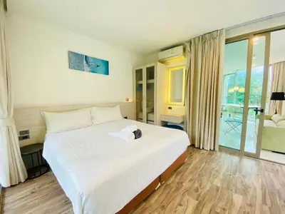 a bedroom with a large white bed and a balcony at A16 Oceana Kamala in Kamala Beach