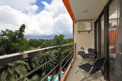 a balcony with chairs and a view of trees at MBC by Capital Pro in Mai Khao Beach