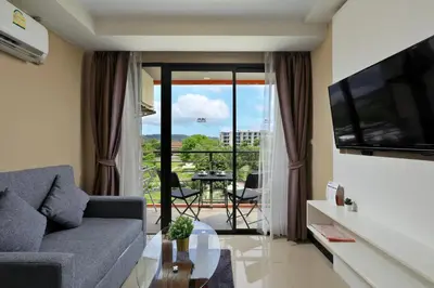 a living room with a couch and a glass table at MBC by Capital Pro in Mai Khao Beach