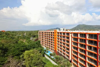 an orange and white building in the middle of a forest at MBC by Capital Pro in Mai Khao Beach