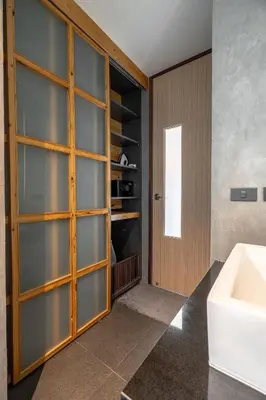 a bathroom with a sink and a wooden door at Studio Sora Rooftop Pool ReLife Nai Harn Beach in Rawai Beach
