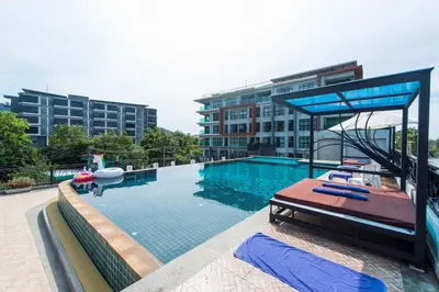 a swimming pool with lounge chairs and a hotel at Golden Manora Hotel Bangtao Beach Phuket in Bang Tao Beach