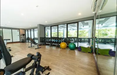 a gym with exercise equipment and a large window at 2 bedrooms Condos in Bangtao in Bang Tao Beach