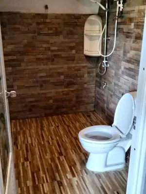 a bathroom with a toilet and a brick wall at Mountain View Resort in Nai Yang Beach
