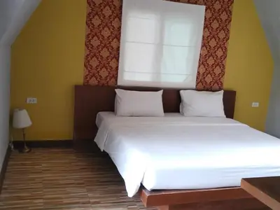 a bedroom with a large bed with a window at Mountain View Resort in Nai Yang Beach