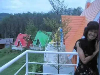 a woman standing on the balcony of a house at Mountain View Resort in Nai Yang Beach