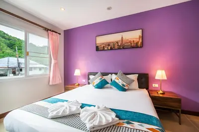 a purple bedroom with a bed and a window at patong villa3 \u56db\u5367\u6d77\u666f\u6cf3\u6c60\u522b\u5885 \u8fd1\u73ed\u8d5e\u6d77\u9c9c\u5e02\u573a \u4e2d\u82f1\u6cf0\u4e09\u8bed\u670d\u52a1 in Patong Beach