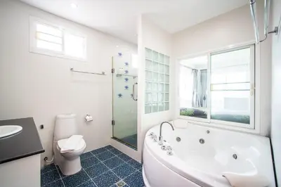 a white bathroom with a tub and a toilet at patong villa3 \u56db\u5367\u6d77\u666f\u6cf3\u6c60\u522b\u5885 \u8fd1\u73ed\u8d5e\u6d77\u9c9c\u5e02\u573a \u4e2d\u82f1\u6cf0\u4e09\u8bed\u670d\u52a1 in Patong Beach