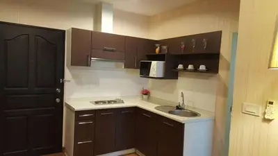 a small kitchen with a sink and a black door at Phuket Villa Patong in Patong Beach