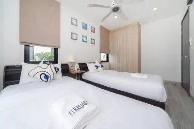 two beds in a hotel room with white sheets at \u666e\u5409\u5c9b\u6700\u8457\u540d\u7684Laguna\u62c9\u53e4\u5a1c \u4e94\u5367\u5ba4\u79c1\u4eba\u6cf3\u6c60\u522b\u5885 \u5bbd\u655e\u8212\u9002 in Phuket Town