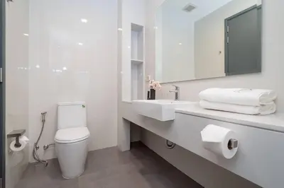 a white bathroom with a toilet and a sink at \u666e\u5409\u5c9b\u6700\u8457\u540d\u7684Laguna\u62c9\u53e4\u5a1c \u4e94\u5367\u5ba4\u79c1\u4eba\u6cf3\u6c60\u522b\u5885 \u5bbd\u655e\u8212\u9002 in Phuket Town